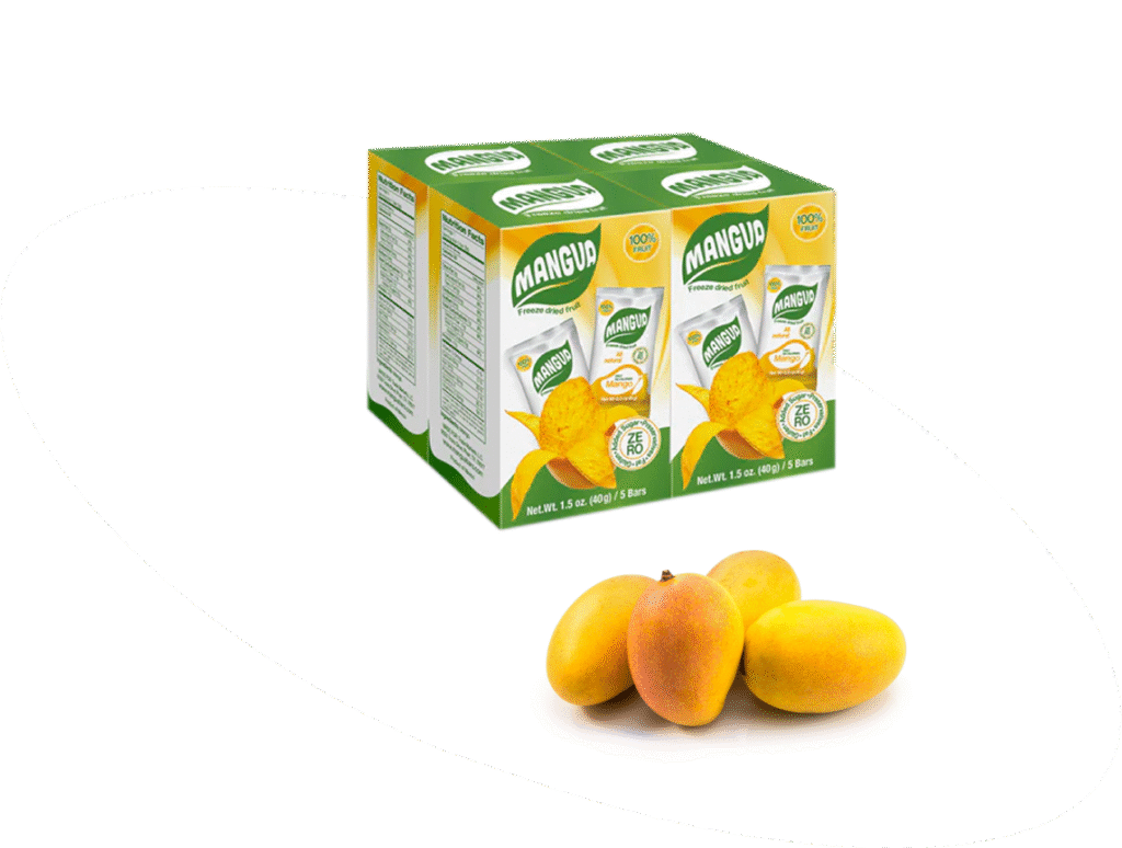 Box of MANGUA freeze-dried mango snacks next to fresh mangoes on a white background.